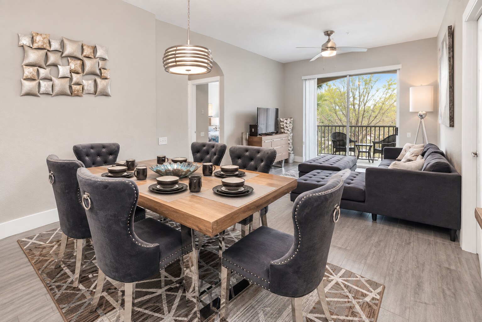 Dining room with six upholstered chairs opening into the living room and balcony